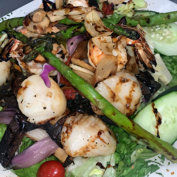 Close-up of Jo-Jo's Italian Grille's grilled scallop and shrimp salad with asparagus and onions.