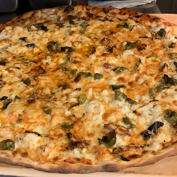 A Jo-Jo's Italian Grille pizza, generously topped with melted cheese, chicken, and green peppers.